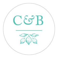 A vintage monogram adorned with deep aqua, intricate botanical accents contrasts against a white background for the In the Garden Wedding Stickers.