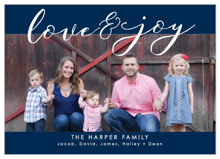 Our Love & Joy Photo Holiday Cards feature a classic color combination of navy blue and snow white; with your photo serving as the primary backdrop, a gentle cursive spelling out your holiday greetings along the top, and a modern print sharing your family names along the bottom, these cards are a perfect fit for this holiday season.