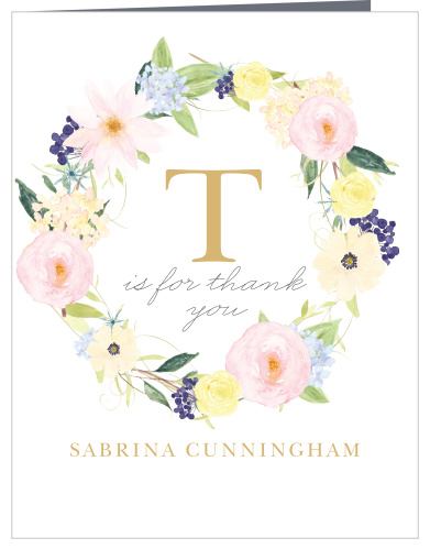 A large, monogrammed and gold foiled "T" sits within a softly colored flower crown.