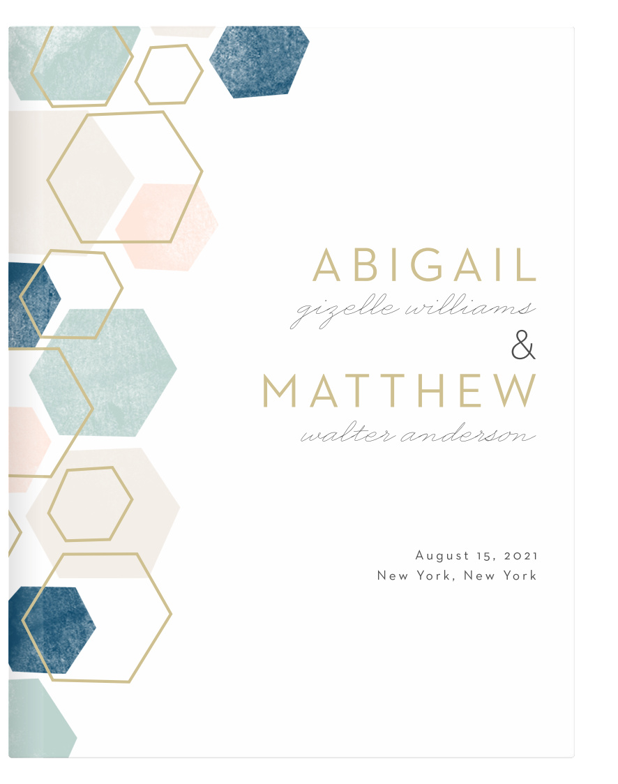 A geometric pattern in pink and blue hues with some gold hexagon outlines graces the left side of the front cover of our Geometric Watercolor Guest Books.